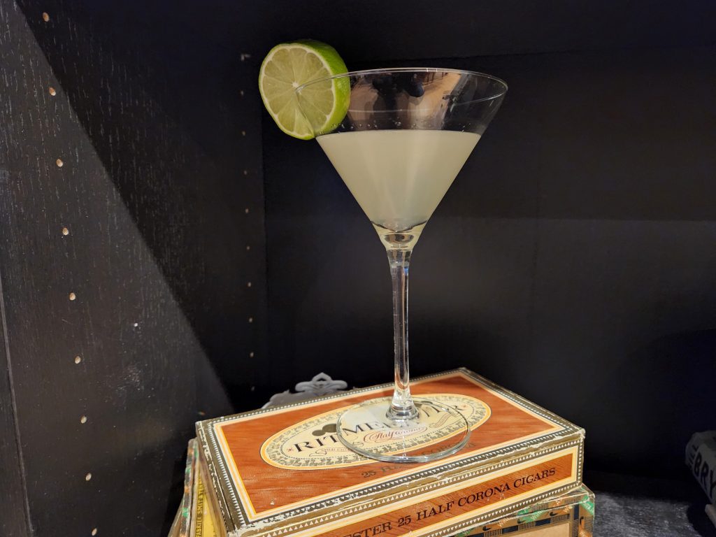 A Classic Daiquiri in a Martini glass on top of a cigar box.