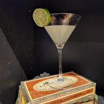 A Classic Daiquiri in a Martini glass on top of a cigar box.