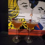 Two Bella Donna Daiquiris in front of a painting.