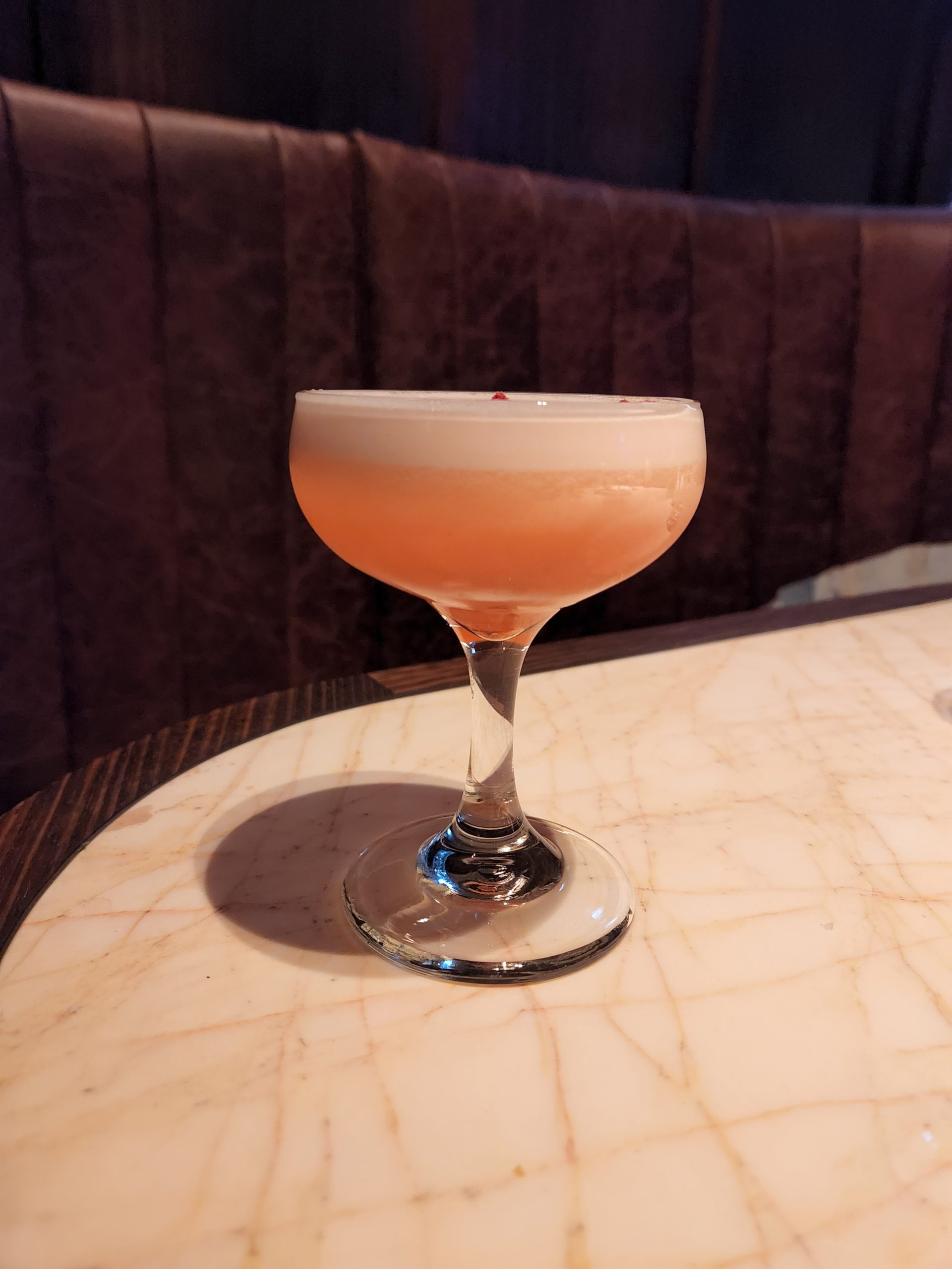 A Clover Club Cocktail on a bar table.