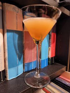 A Fancy Whiskey Cocktail in front of some books.