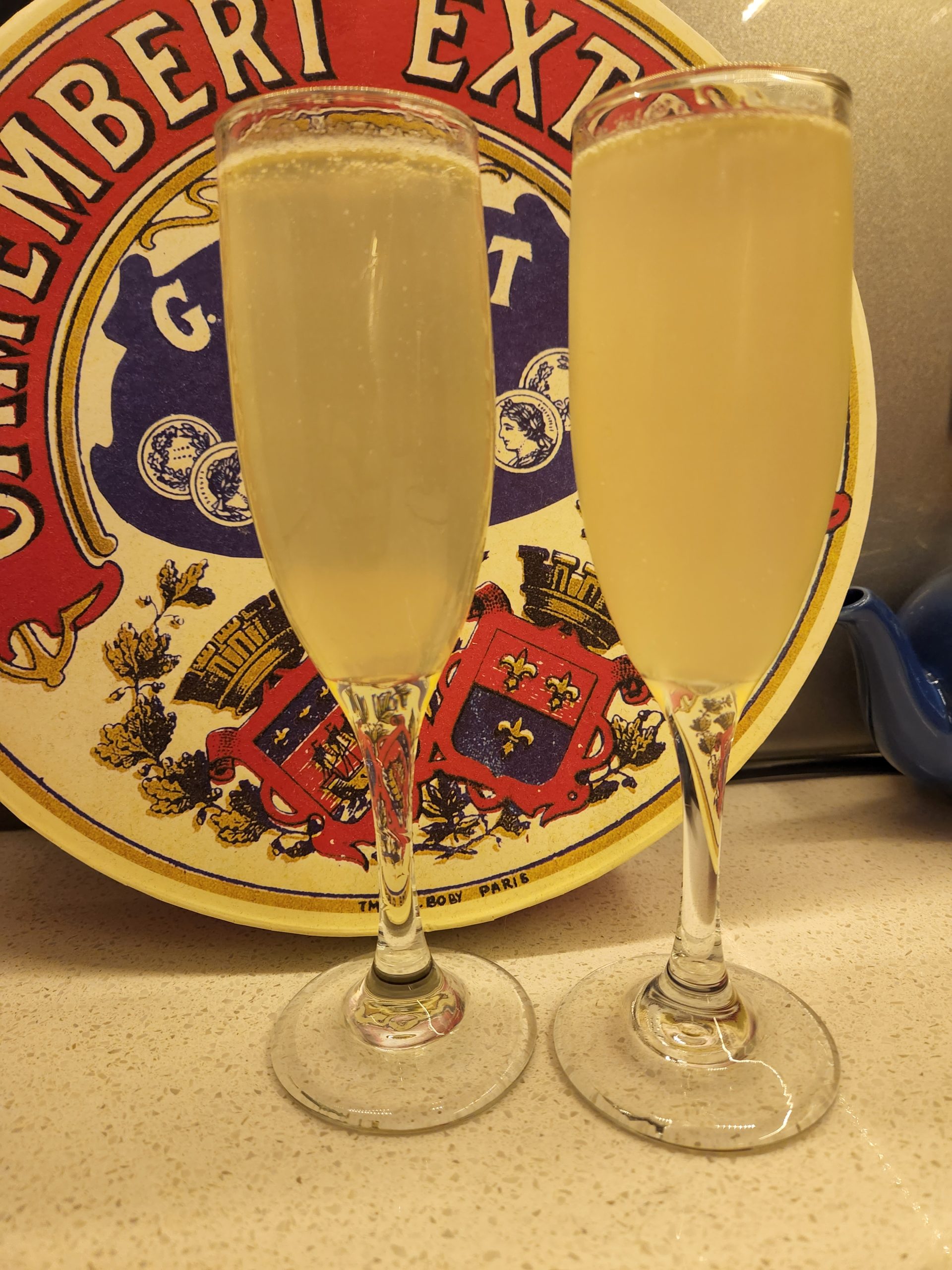 Two French 75 cocktails in Champagne flutes.