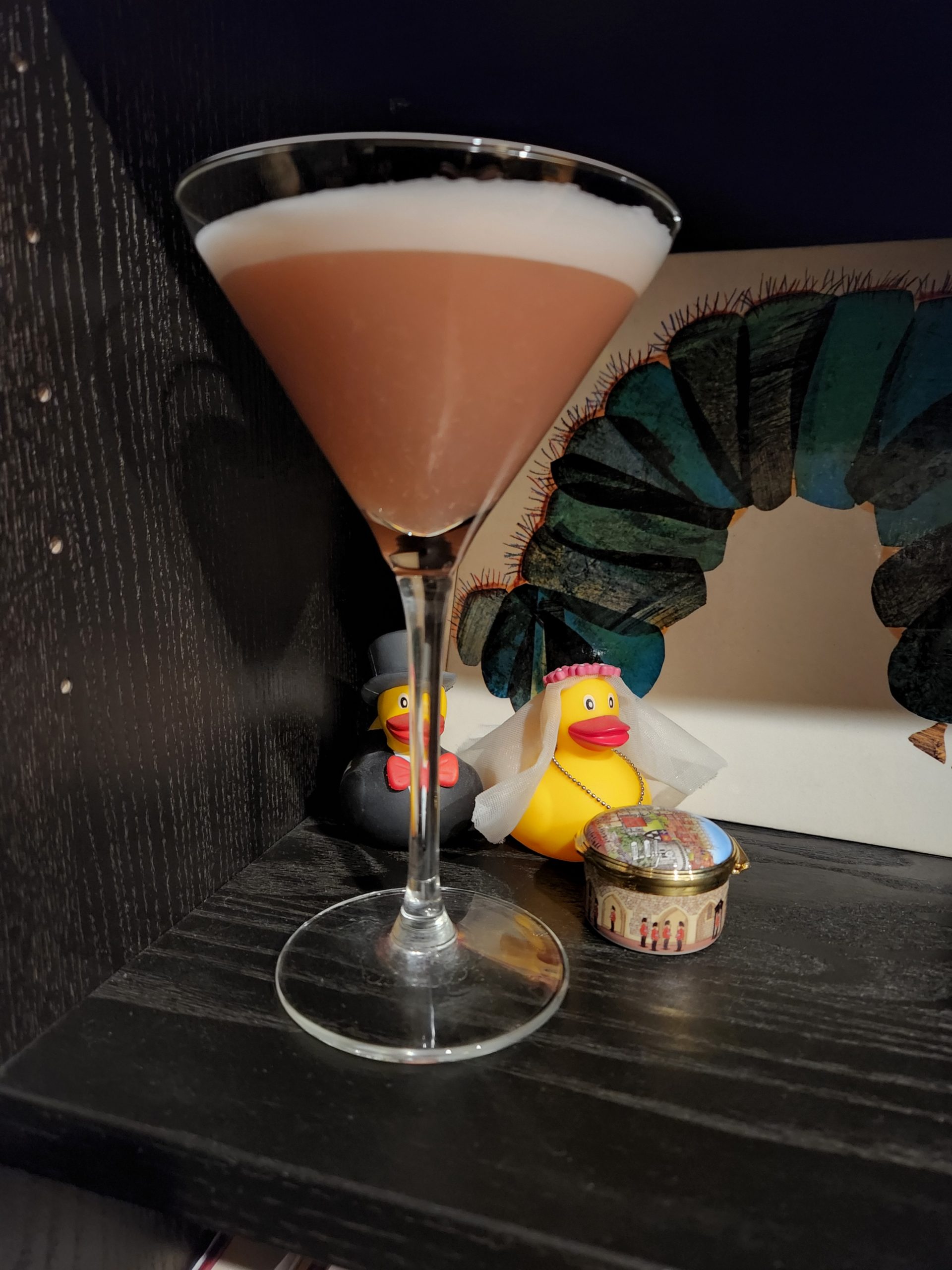 A Million Dollar Cocktail in front of two miniature rubber ducks.