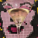 A Reverse Martini in front of a pop art style portrait of Marilyn Monroe.