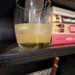 A Scotch Sour cocktail next to some books.