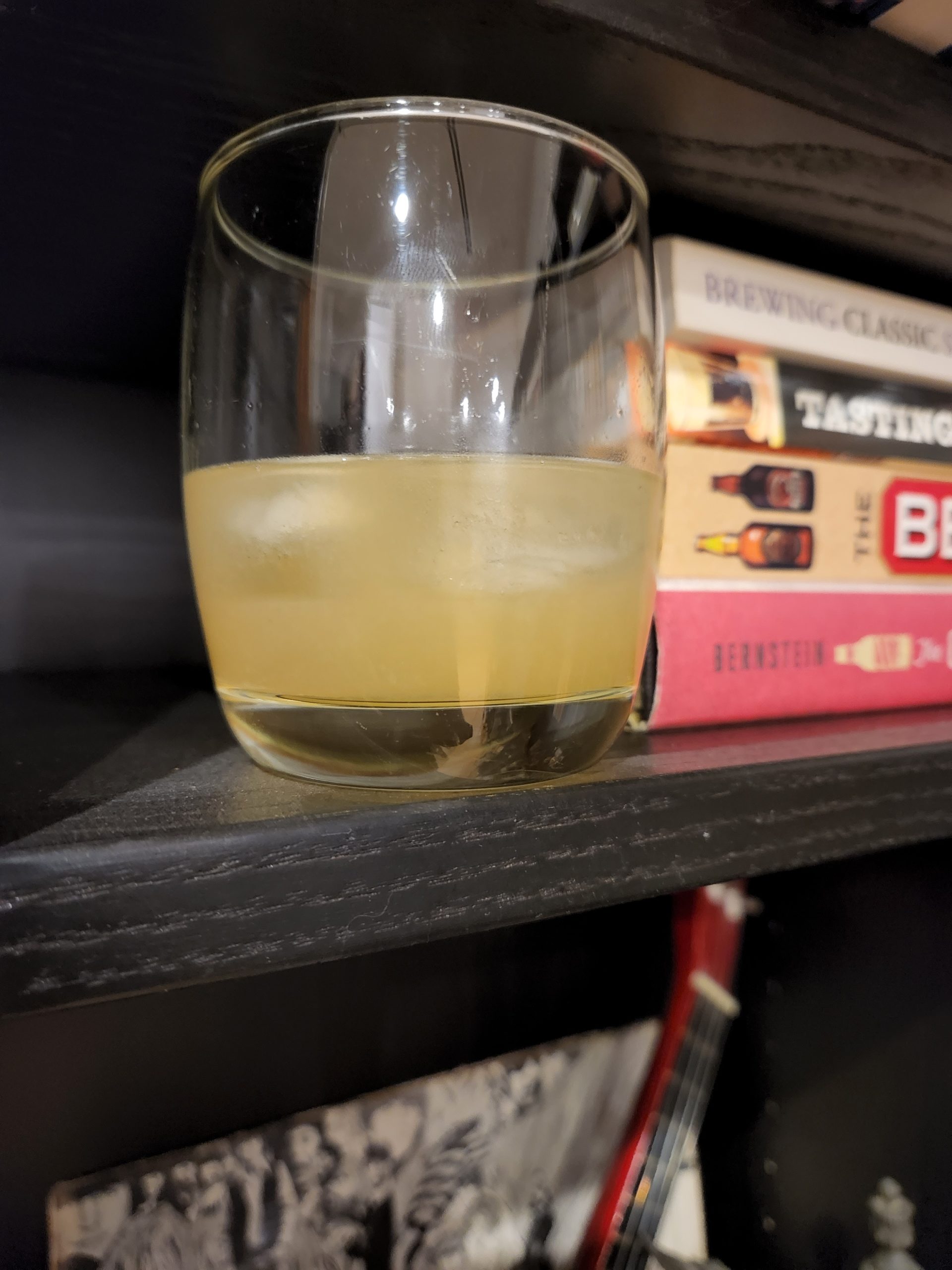 A Scotch Sour cocktail next to some books.