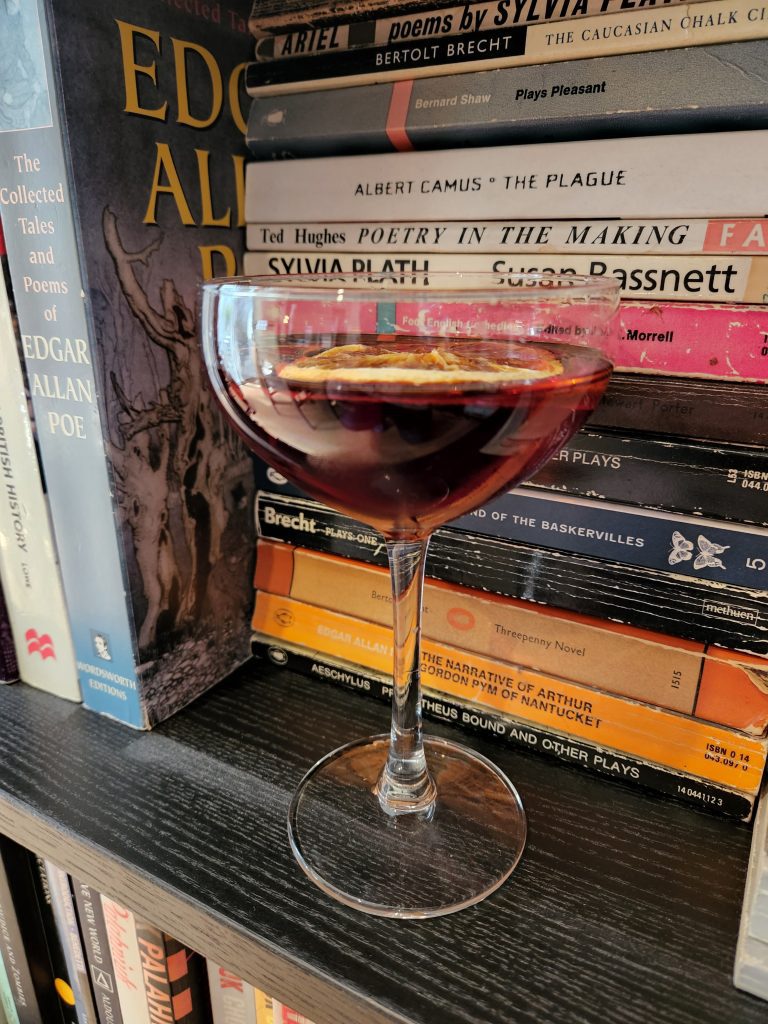 A Blood and Sand cocktail on a bookshelf.