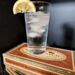 A Gin and Tonic sitting on cigar boxes.