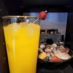 A Harvey Wallbanger cocktail in front of a bowl of rocks.