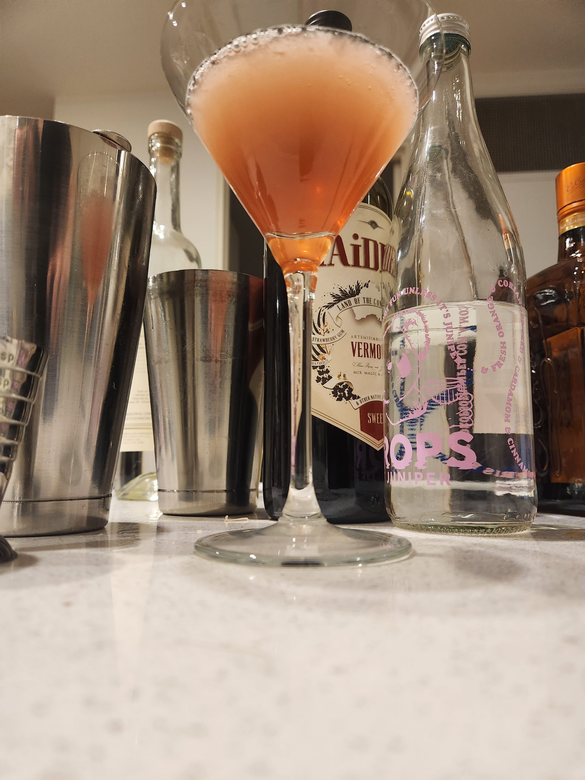 A Hanky Panky Cocktail with various ingredients behind it.