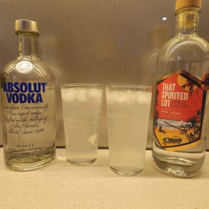 Two glasses of Kansas City Ice Water with a bottle of vodka and a bottle of gin.