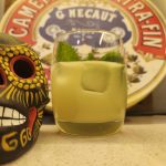 A Mezcal Mai Tai cocktail with a ceramic skull next to it.